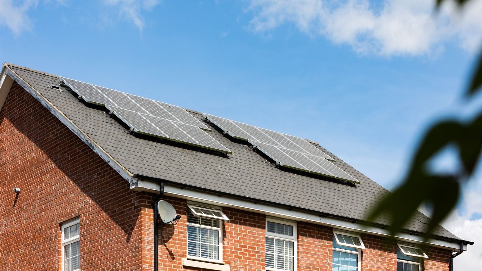 Brick house with solar panels under a blue sky