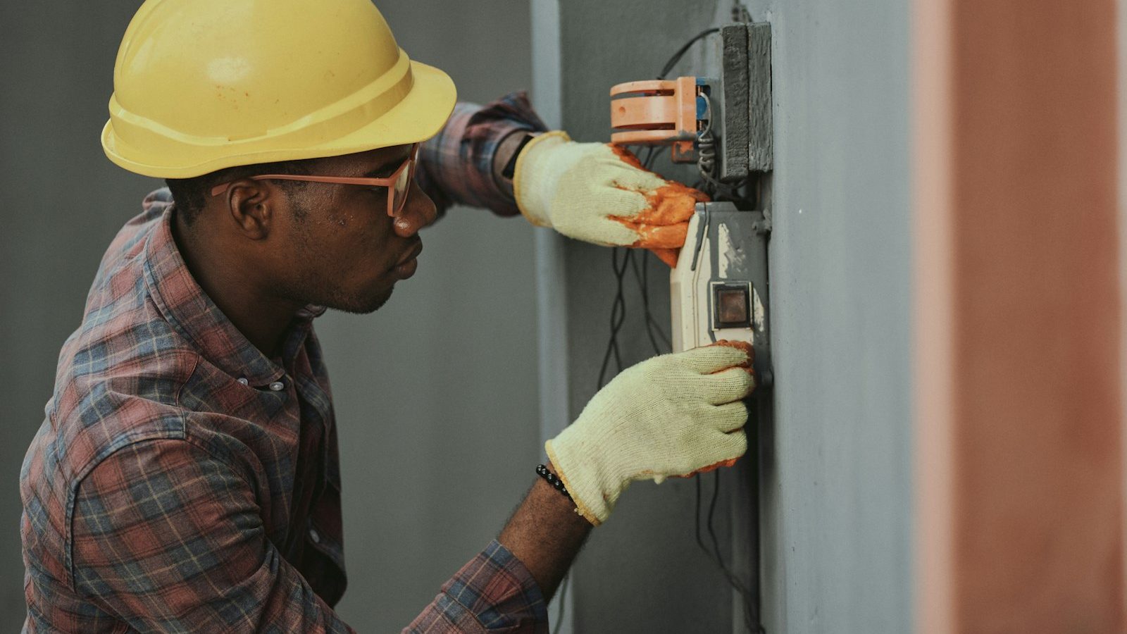 Electrician in a hard hat installing wiring