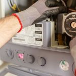 Hands adjusting boiler controls
