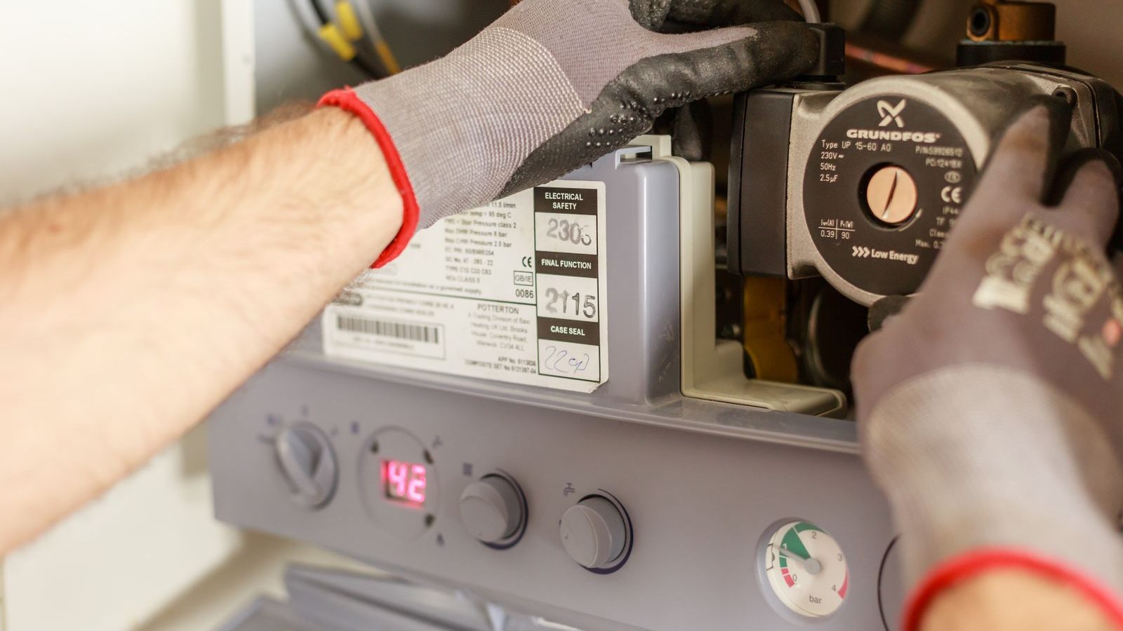 Hands adjusting boiler controls