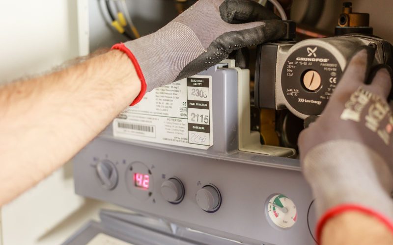 Hands adjusting boiler controls