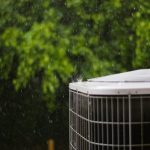Close-up of a heat pump condenser outdoors in the rain