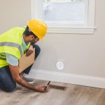 Home inspector checking a floor vent and ductwork