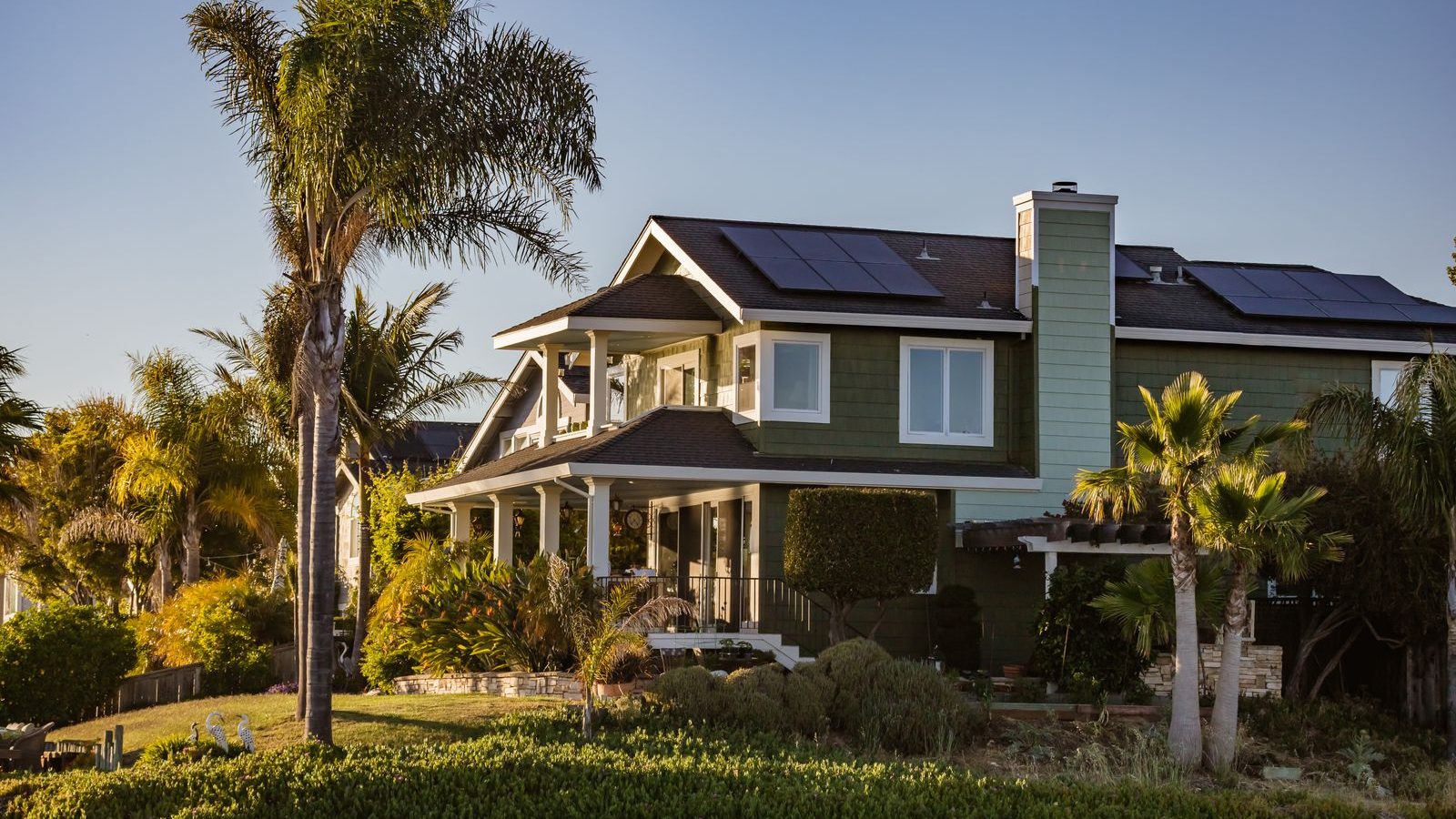 Home with solar panels and garden by a river