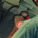 HVAC technician checking refrigerant pressure