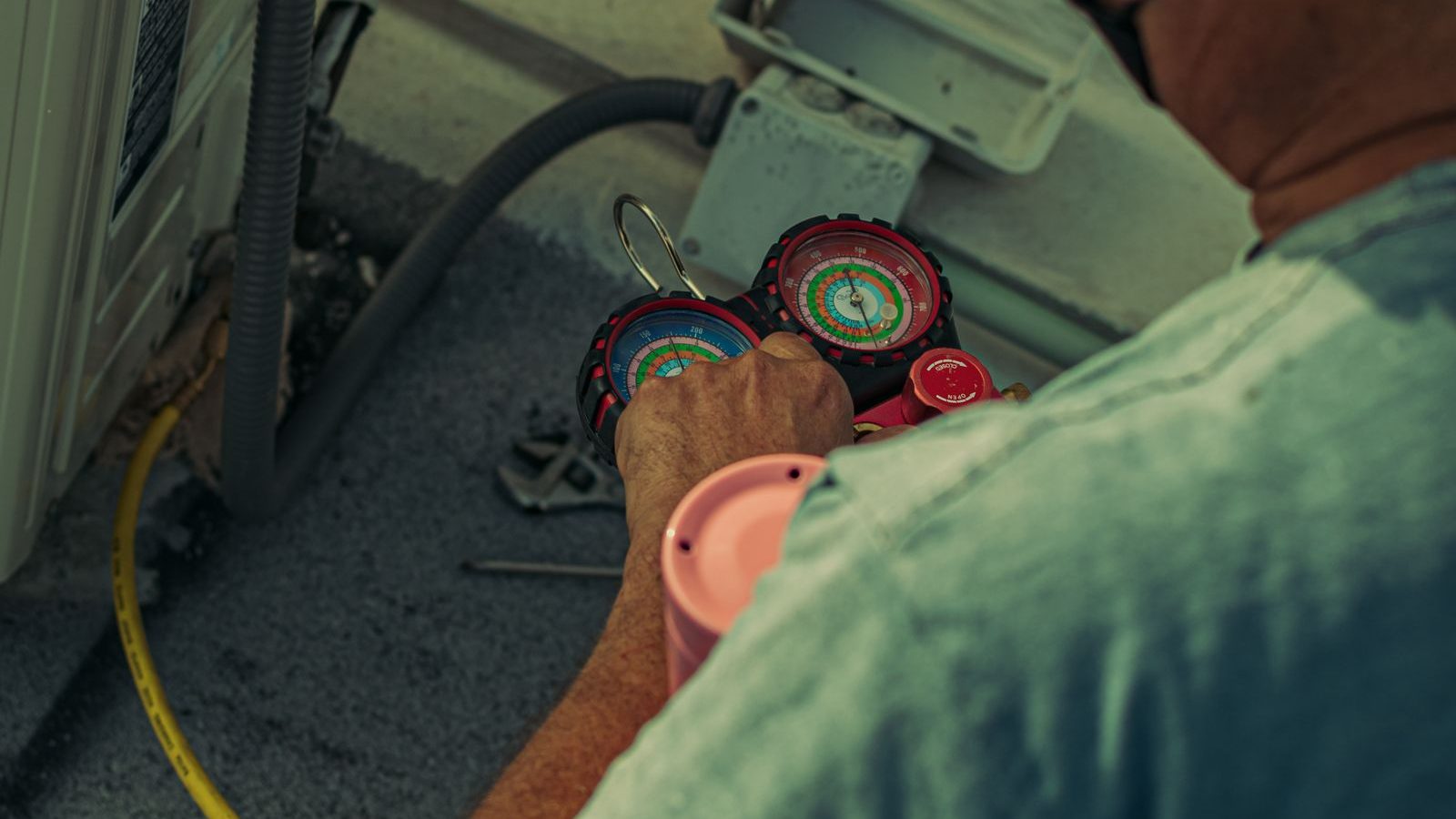 HVAC technician checking refrigerant pressure