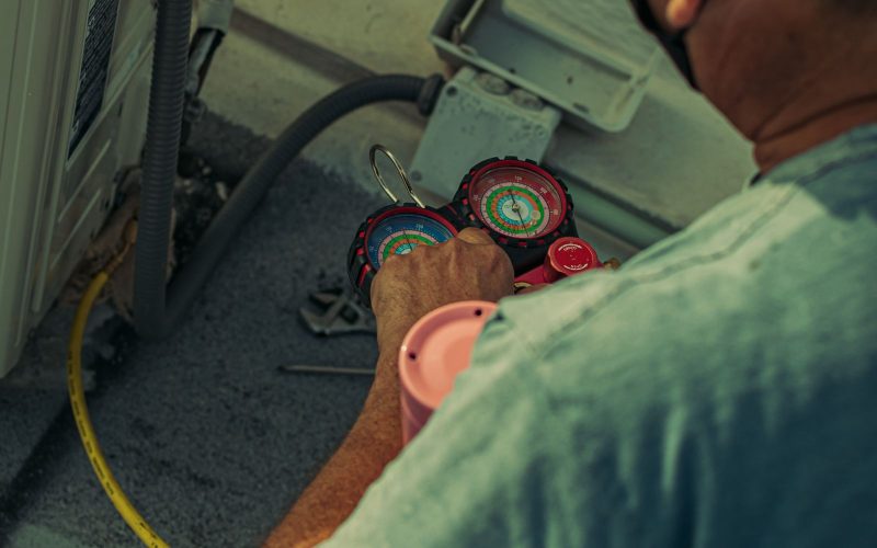 HVAC technician checking refrigerant pressure