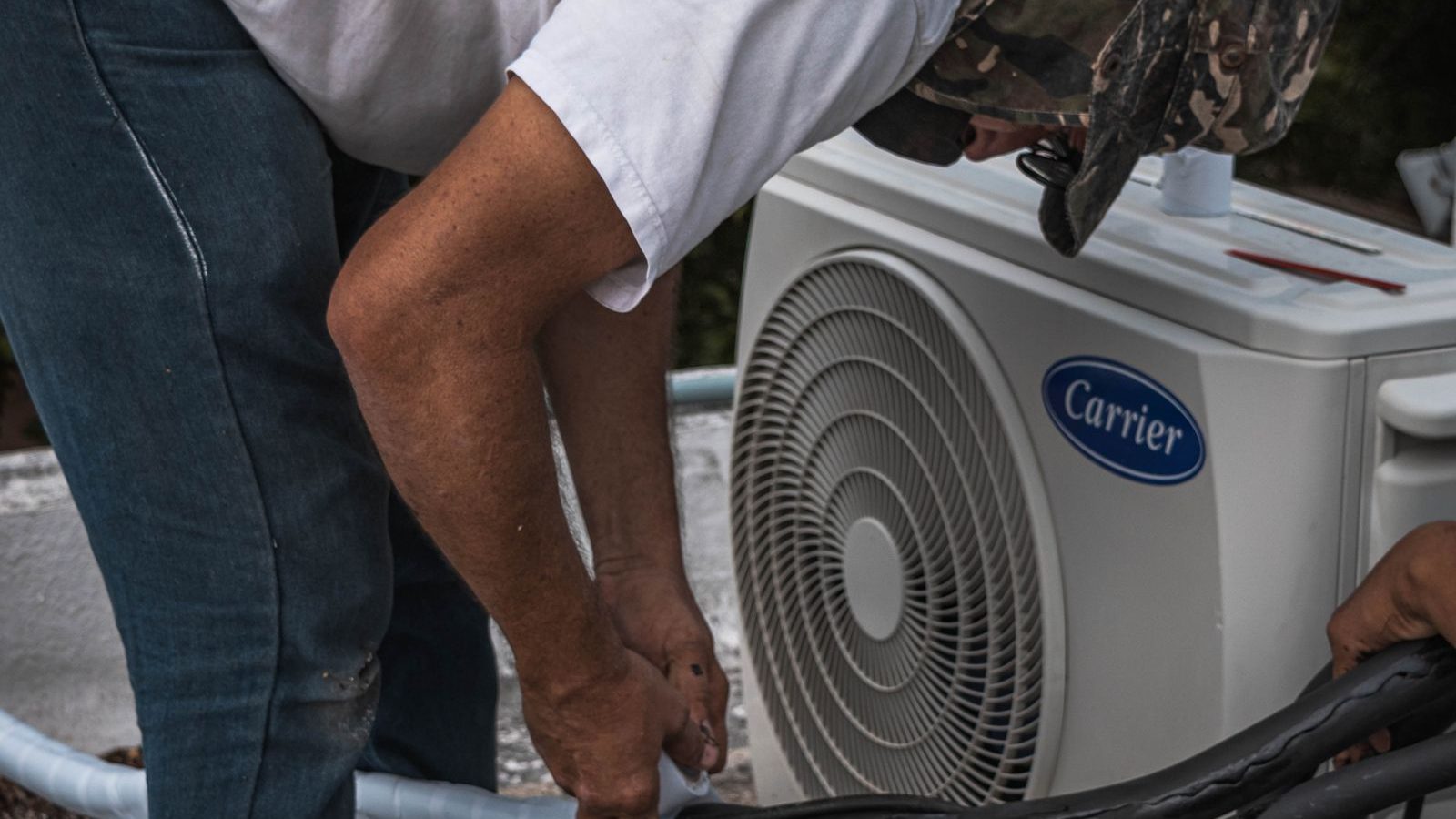 HVAC technician servicing a heat pump outdoor unit