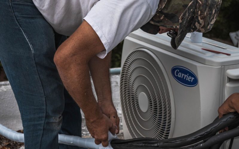 HVAC technician servicing a heat pump outdoor unit