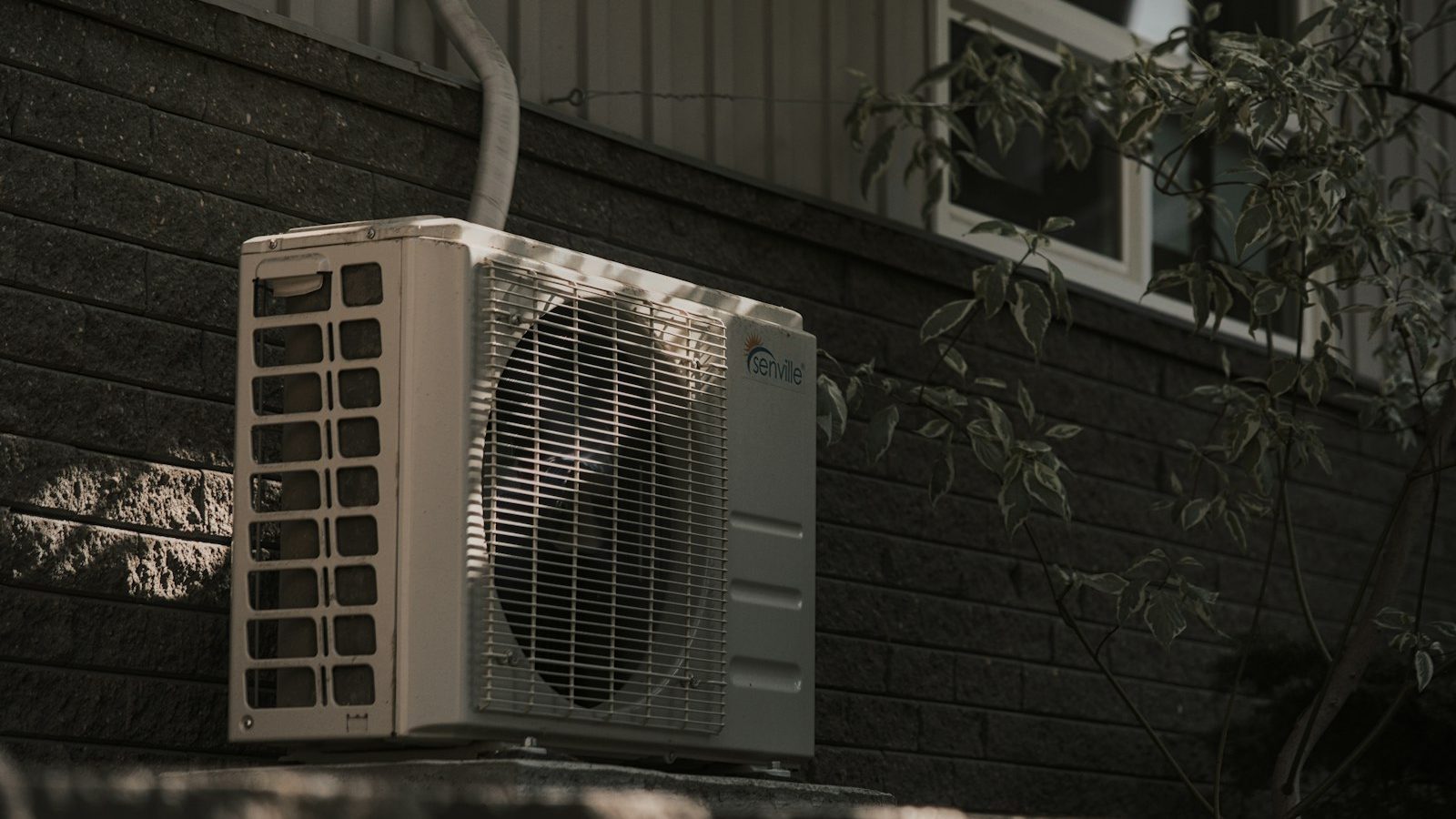 Mini-split outdoor condenser mounted on a brick wall