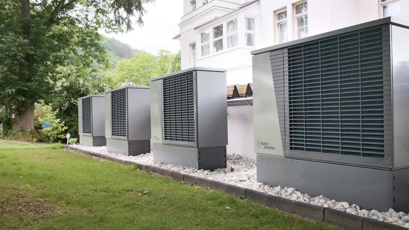 Row of heat pump units lined up outside a building