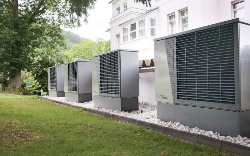 Row of heat pump units lined up outside a building